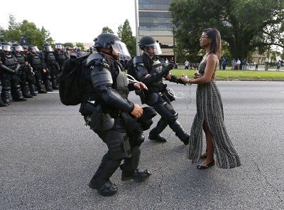 Empowering Photo Of Black Woman Peacefully Protesting Against Officers In Riot Gear Goes Viral