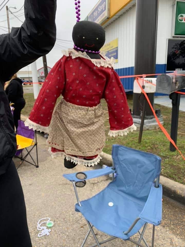 Black Doll Hanging From Noose Made Of Beads Given To Child During Mardi Gras Parade